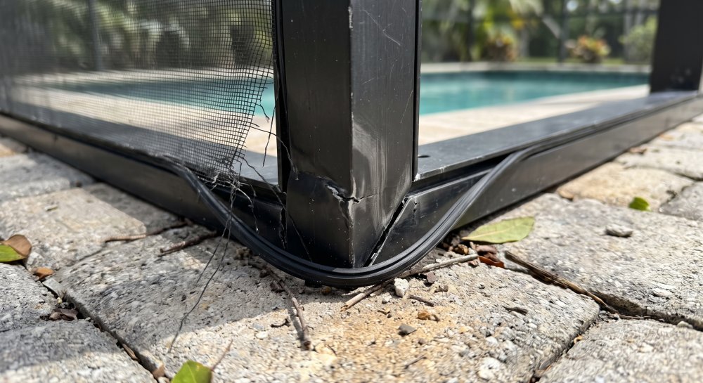 Bent aluminum pool cage frame corner and torn screen after a hurricane in Sarasota, FL