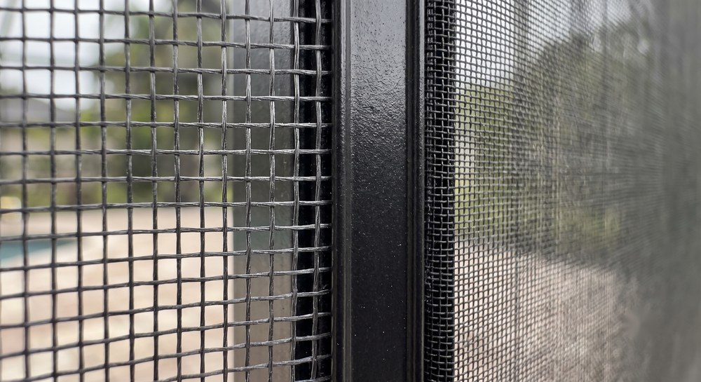 Standard fiberglass and no-see-um pool cage screen weave shown side by side, Sarasota FL